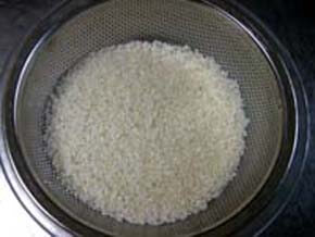 お米をざるを使って洗い水を切る